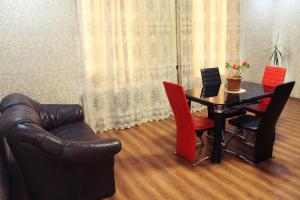 a living room with a table and a leather couch at guest house guru in Kutaisi