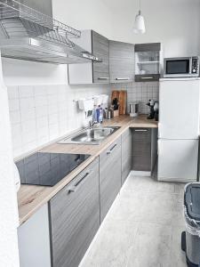 eine Küche mit einer Spüle und einem weißen Kühlschrank in der Unterkunft Zentrum, 4Personen, privater Parkplatz, WiFi, modern, ruhig in Chemnitz