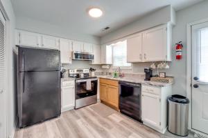 a kitchen with white cabinets and a stainless steel refrigerator at Bowling Green Vacation Rental Near WKU and Downtown! in Bowling Green
