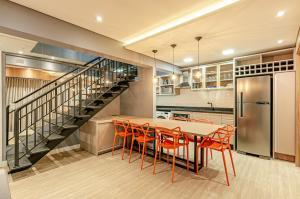 uma cozinha com uma mesa e cadeiras e uma escadaria em Lifespace Curitiba - Duplex Incrível, 2 Quartos, varanda, 2 garagens Batel em Curitiba