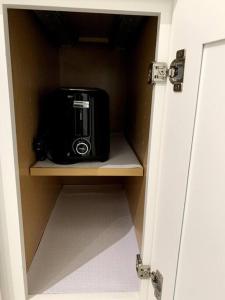 a microwave sitting on a shelf in a closet at The Eagles Retreat in Houston