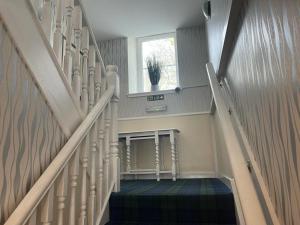 a hallway with a staircase with a window and a stair case at Castle View Accommodation in Inverness