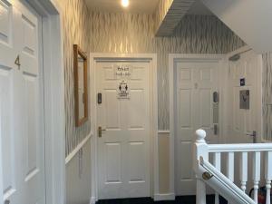 un pasillo con una puerta blanca con un cartel. en Castle View Accommodation, en Inverness