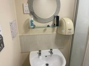 W łazience znajduje się umywalka i lustro. w obiekcie Castle View Accommodation w mieście Inverness