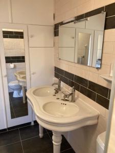 een badkamer met een witte wastafel en een spiegel bij La maison du pech in Monteils