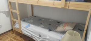 Litera en una habitación pequeña con literas y utensilios de cocina en piso en Vallecas, en Madrid
