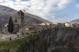 une ville au bord d'une montagne avec une tour dans l'établissement Can Mosqueroles casa en Castellfollit de la Roca, à Gérone