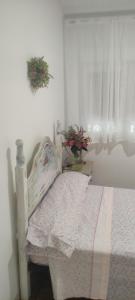 1 dormitorio con cama blanca y ventana en piso en Vallecas, en Madrid