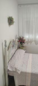 Un dormitorio con una cama blanca y una ventana. en piso en Vallecas, en Madrid