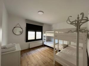 1 dormitorio con 2 literas y ventana en Can Mosqueroles casa en Castellfollit de la Roca en Girona
