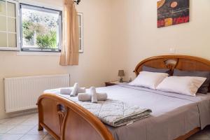 a bedroom with a bed with two stuffed animals on it at Come and Sea apartment in Vlachata