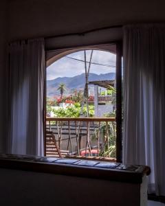 a room with a window with a view of a balcony at Baxar in Pie de la Cuesta