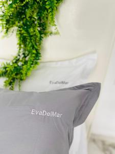 un cuscino su un letto con una pianta verde di Eva Del Mar - Sea view - Mamaia Nord a Mamaia