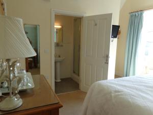 a bedroom with a bed and a table with a lamp at Staylittle Farm in Dolgellau +4 photos