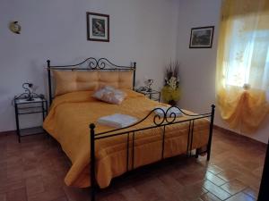 a bedroom with a bed with yellow sheets and a window at Agriturismo San Luciano in Radicofani