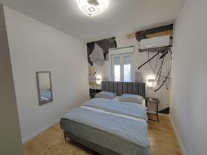 Un dormitorio con una cama en una habitación blanca. en Town Square Apartment, en Zadar