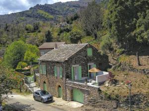 una casa de piedra con un coche aparcado delante de ella en U Castellu di A Sulana, en Casabianca