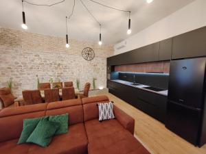 Una sala de estar con un sofá y un comedor. en Town Square Apartment, en Zadar