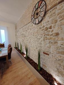 Una pared de ladrillos con un reloj en una pared con plantas. en Town Square Apartment, en Zadar 31 fotos más