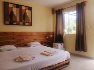 Guest house La Casa del Quetzal في ميريدا: غرفة نوم عليها سرير وفوط