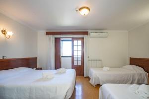 a hotel room with two beds and a window at Santa Barbara by Umbral in Fátima