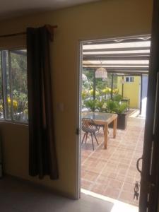 eine Tür, die auf eine Terrasse mit einem Tisch und Stühlen führt in der Unterkunft Guest house La Casa del Quetzal in Mérida