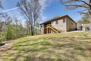 a house on top of a grassy hill at Biking Haven Charming Bella Vista Home with Games! in Bella Vista