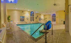a swimming pool in a large room with chairs and tables at La Quinta by Wyndham Milwaukee Delafield in Delafield +23 photos
