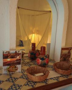 a table with baskets on top of a tiled floor at Baxar in Pie de la Cuesta