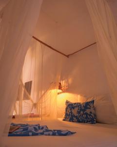 a bedroom with a white canopy bed with a pillow at Baxar in Pie de la Cuesta