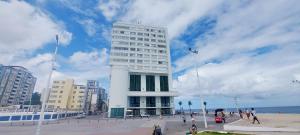 a tall white building with people standing around it at COBAR0108 - Edifício Oceania in Salvador