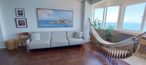 a living room with a hammock and a couch at COBAR0108 - Edifício Oceania in Salvador