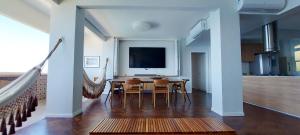 a dining room with a table and a tv at COBAR0108 - Edifício Oceania in Salvador