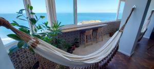 a hammock in a room with a view of the ocean at COBAR0108 - Edifício Oceania in Salvador