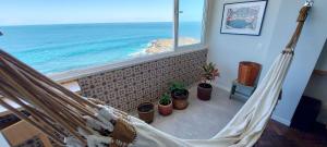 a hammock in a room with a view of the ocean at COBAR0108 - Edifício Oceania in Salvador