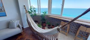 a hammock in a room with a view of the ocean at COBAR0108 - Edifício Oceania in Salvador