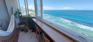a balcony with a view of the ocean from a window at COBAR0108 - Edifício Oceania in Salvador