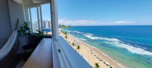 a balcony with a view of a beach and the ocean at COBAR0108 - Edifício Oceania in Salvador