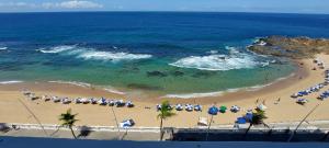 an aerial view of a beach with umbrellas and the ocean at COBAR0108 - Edifício Oceania in Salvador