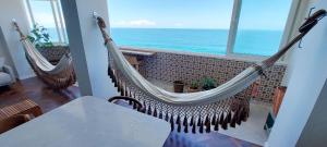 two hammocks in a room with a view of the ocean at COBAR0108 - Edifício Oceania in Salvador