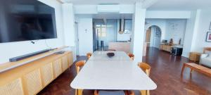 a living room with a table with chairs and a flat screen tv at COBAR0108 - Edifício Oceania in Salvador