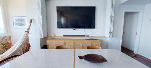 a room with a table and a television on a wall at COBAR0108 - Edifício Oceania in Salvador
