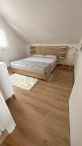 1 dormitorio con 1 cama y suelo de madera en Poggio giaele en Mazzeo