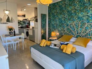 a bedroom with a large bed and a kitchen at Corralejo Tender Suite in Corralejo