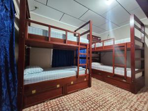 two bunk beds in a room with a room with another bed at Fenix Hotel & Hostel in Utila