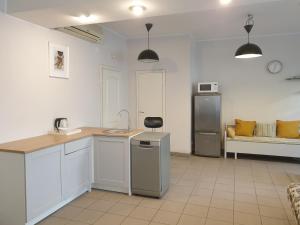 a kitchen with white cabinets and a couch in a room at CAMELLIA STUDIO apartment & parking in Rīga