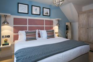 um quarto com uma grande cama branca com paredes azuis em The Farmhouse em Derby