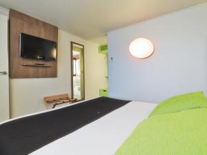 - une chambre avec un lit et une télévision à écran plat dans l'établissement Campanile Epinay sur Orge Savigny Sur Orge, à Épinay-sur-Orge