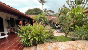 un jardin avec des fleurs et des plantes devant une maison dans l'établissement Villa Adria, à Ilhabela