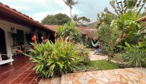 a garden with flowers and plants in front of a house at Villa Adria in Ilhabela